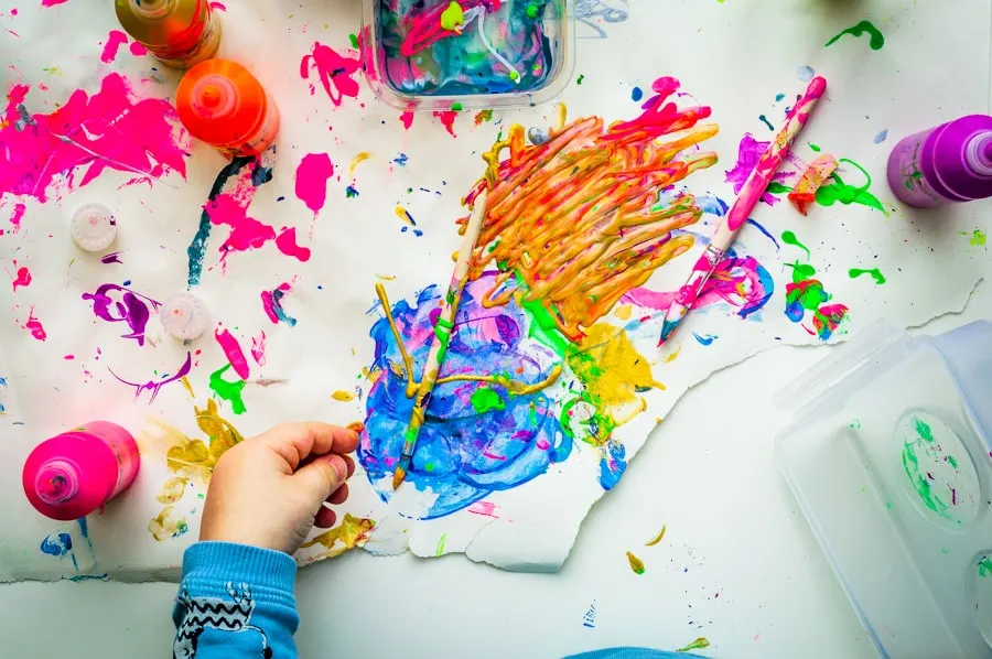Manos de un niño pintando con colores