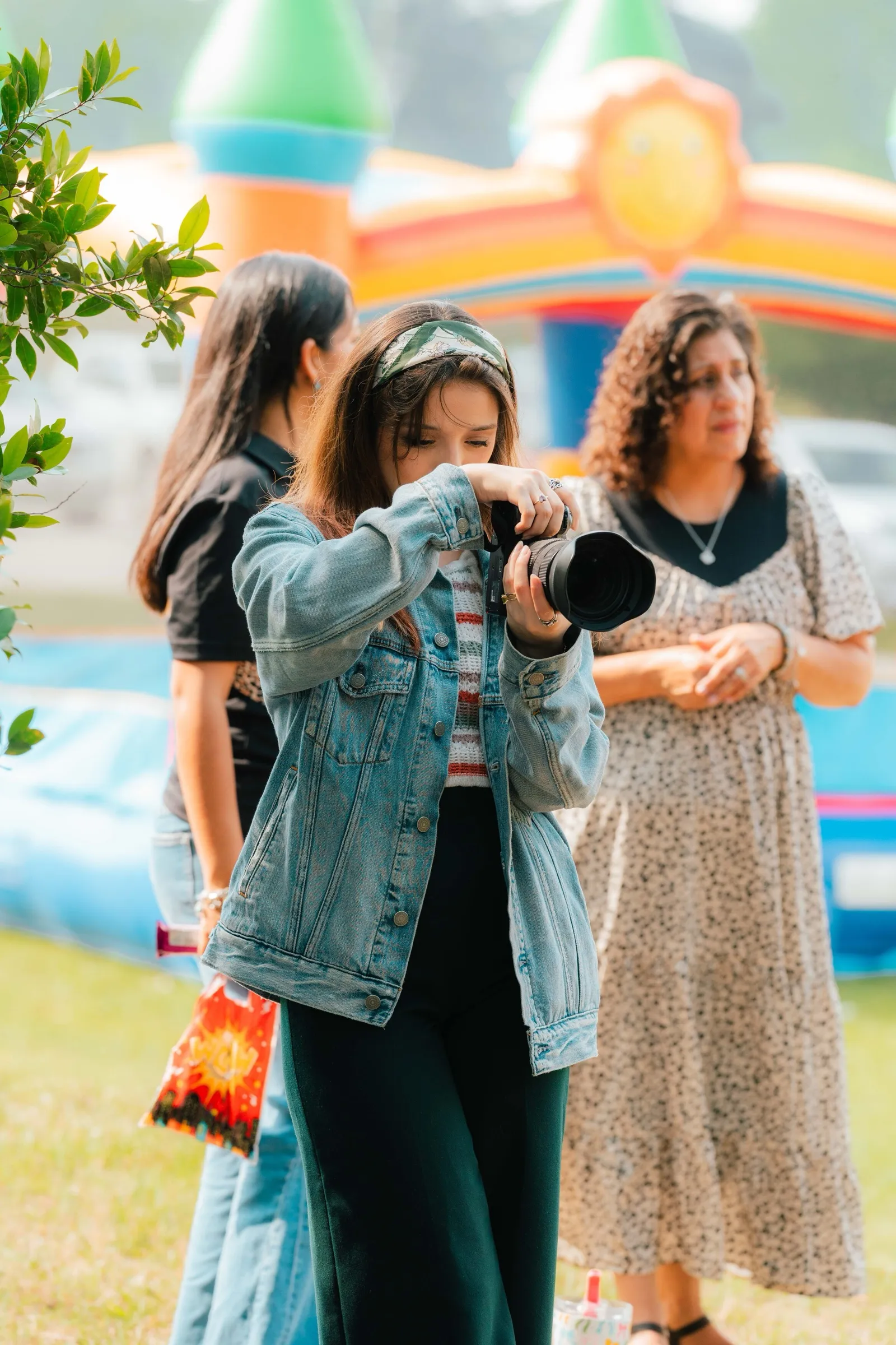 Una joven del equipo de medios fotografía un evento de la iglesia al aire libre