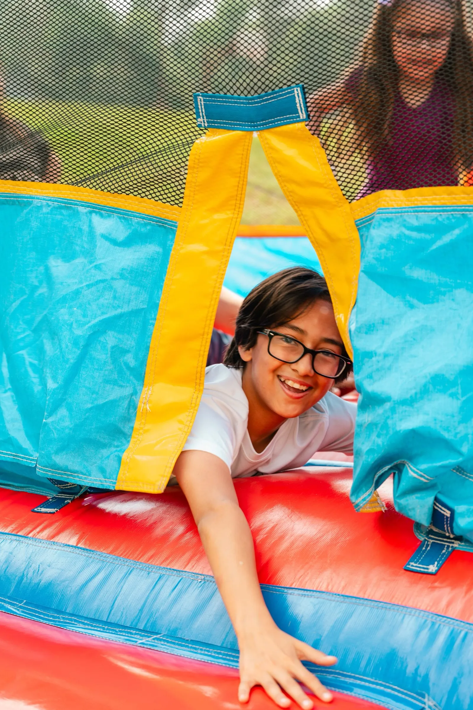 Una niña sonríe al salir de un brincolín durante un evento al aire libre